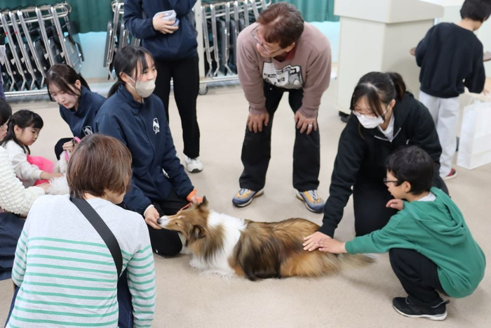 学生の説明に耳を傾ける参加者
