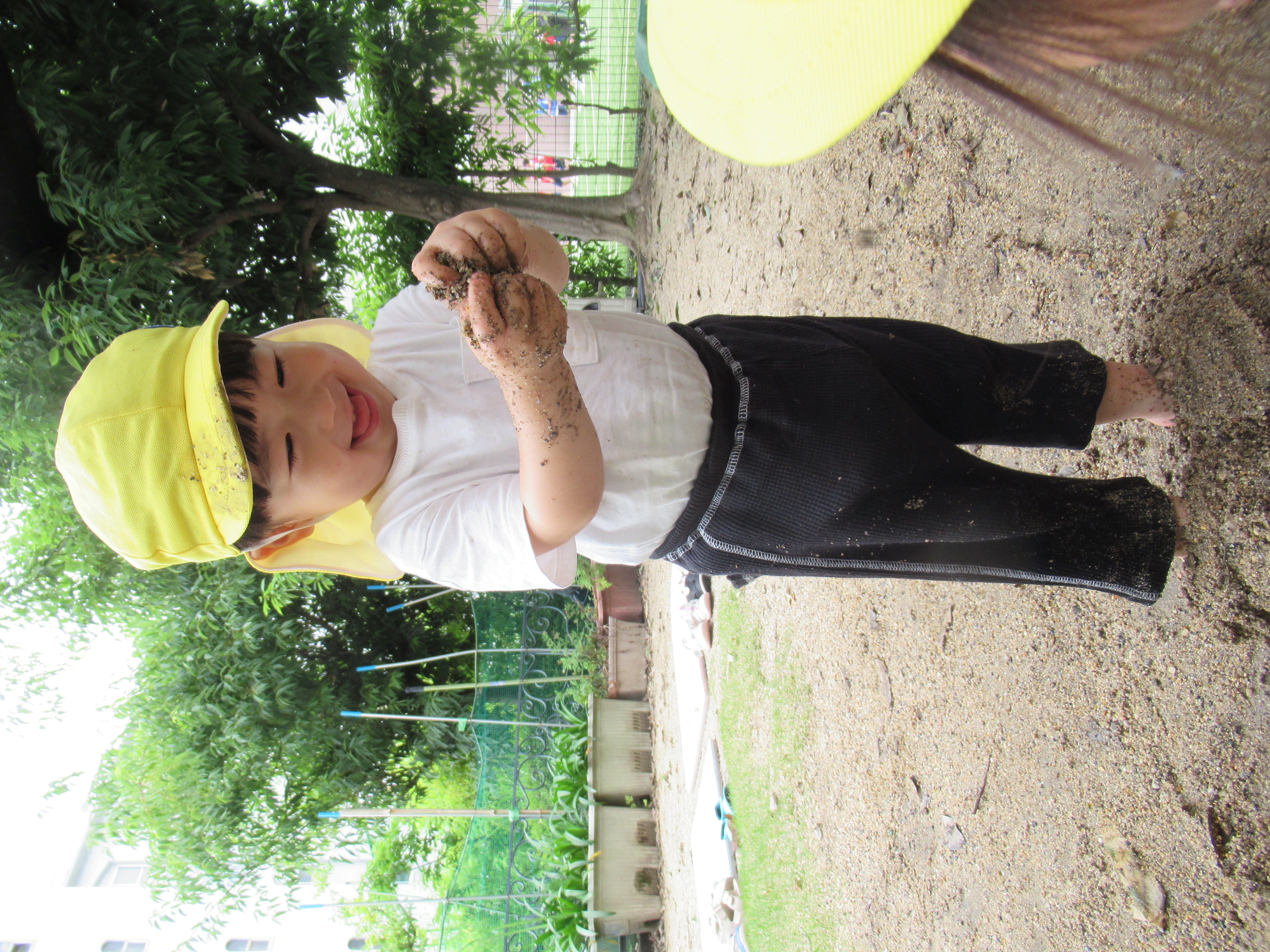 手や足で泥の感触を楽しむ園児