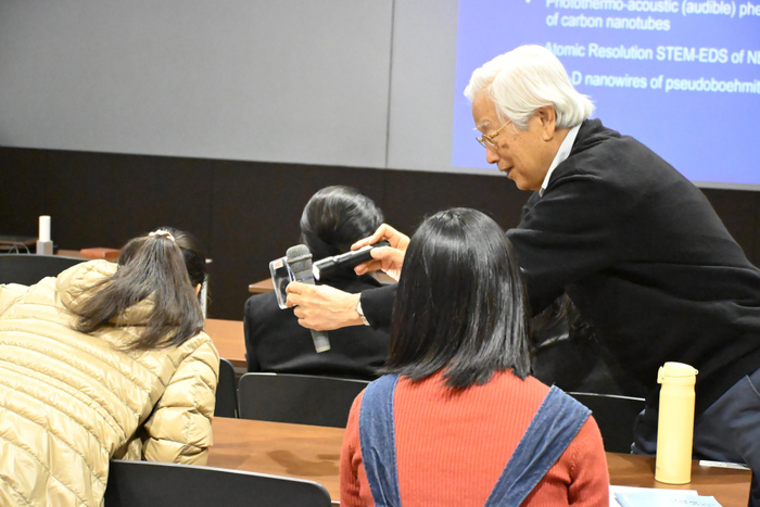 CNTに白色LEDの光を当てて音を出す飯島終身教授