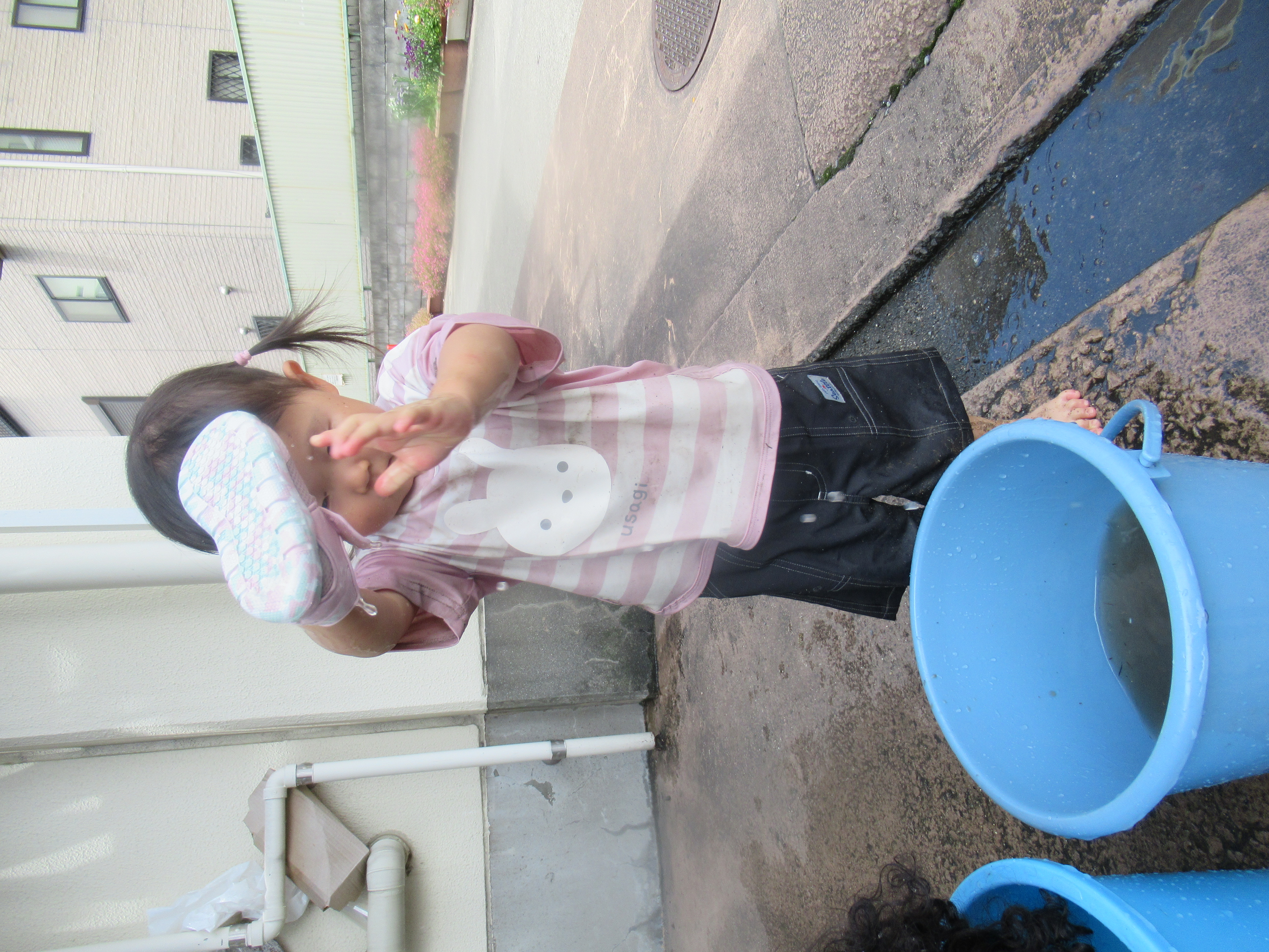 泥のついたサンダルを自分で洗う園児