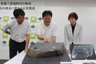 岩石を囲んで会話が弾む（左から）湯川研究員、加藤教授、碇学芸員