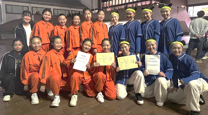  令和6年（2024年）11月のダンスドリル秋季競技大会（中国・四国大会）の様子　高校ダンス部（紺の衣装）、中学校ダンス部（オレンジ・黒の衣装）