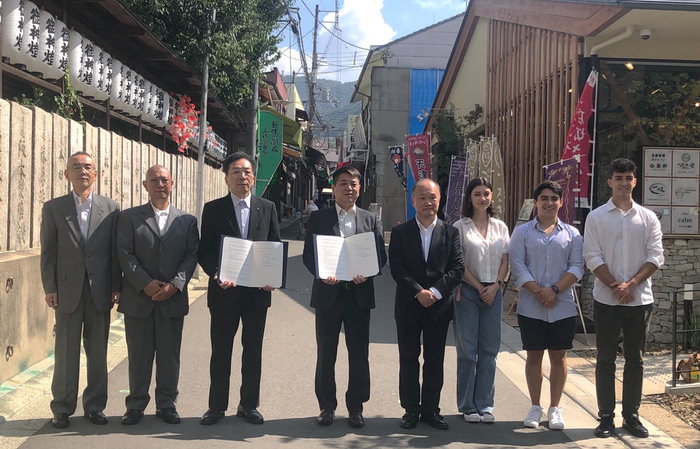 印式での記念撮影の様子(左から、石切参道商店街振興組合石切参道プロジェクトチームリーダー 布一正、同 岩瀬伸一、近畿大学社会連携推進センター長 伊藤哲夫、石切参道商店街振興組合理事長 中澄史雄、近畿大学副学長 渥美寿雄、近畿大学留学生3名)