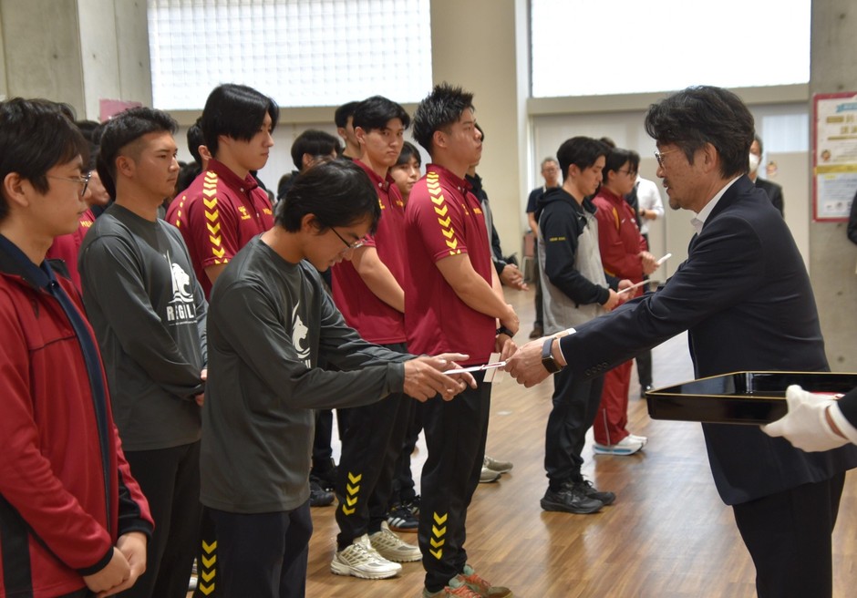 援助金を手渡す校友会の矢野専務理事（右）