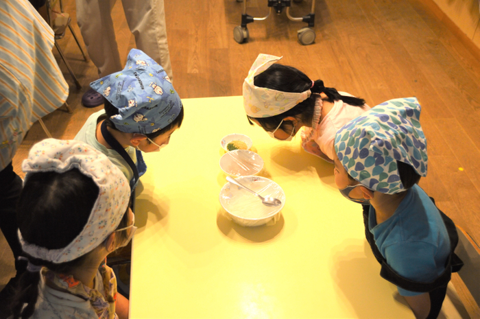 配られたごはんを覗き込む子どもたち