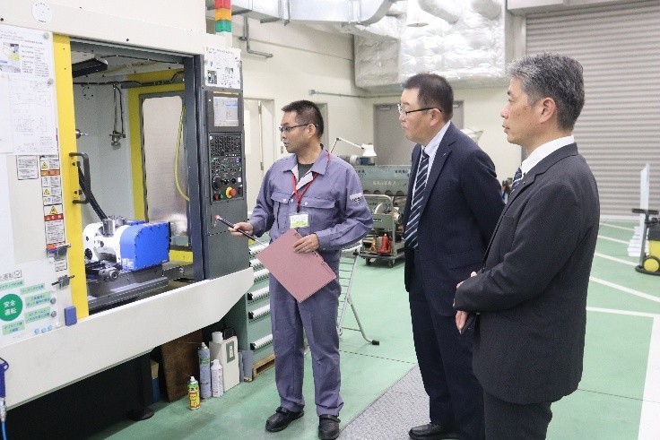 サイエンスドリームラボで寺野元規センター長(左)から機器の説明を受ける烏田社長ら