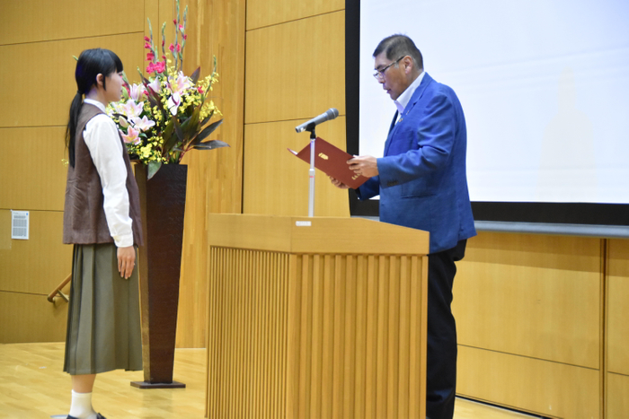 学業優秀奨励者を代表して通知書を受ける林果歩さん