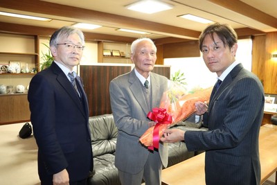 加計理事長（右）から花束を贈られる善木名誉教授（中央）。左は平野学長