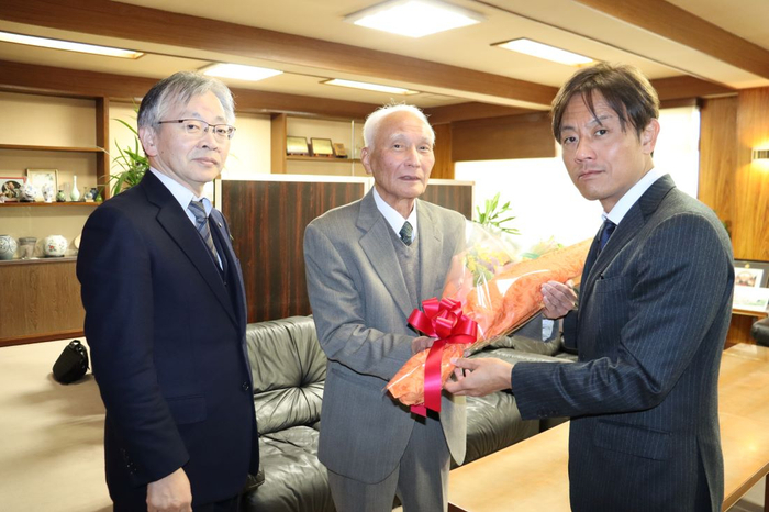 加計理事長(右)から花束を贈られる善木名誉教授(中央)。左は平野学長
