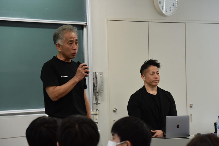 岡田教授を紹介する梅田教授（左）