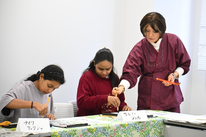 稲原さんの指導を受け練習する学生たち