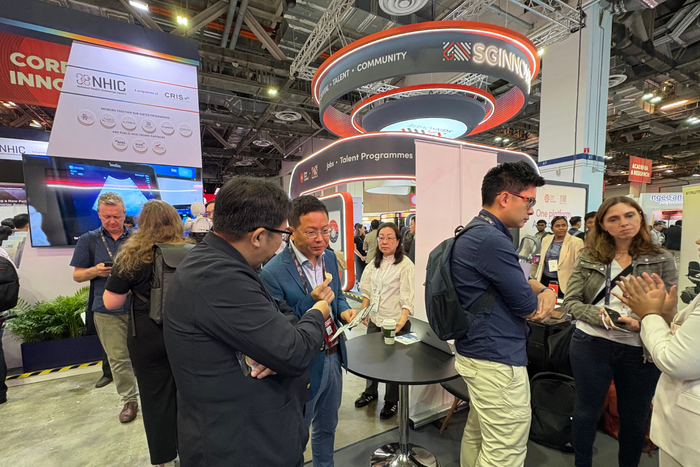 ブースを訪れた人に説明するトイメディカル株式会社代表取締役社長 竹下英徳（左）