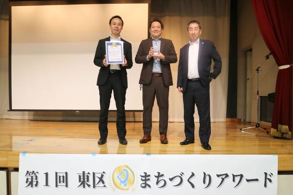 記念盾とトロフィーを手にする まるみつ東バイパス店スタッフ