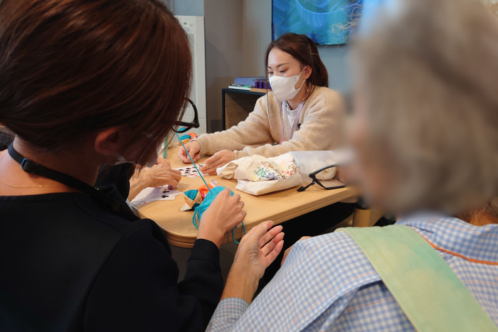 コミナス専従スタッフが病棟に入り、患者さんに寄り添う様子。