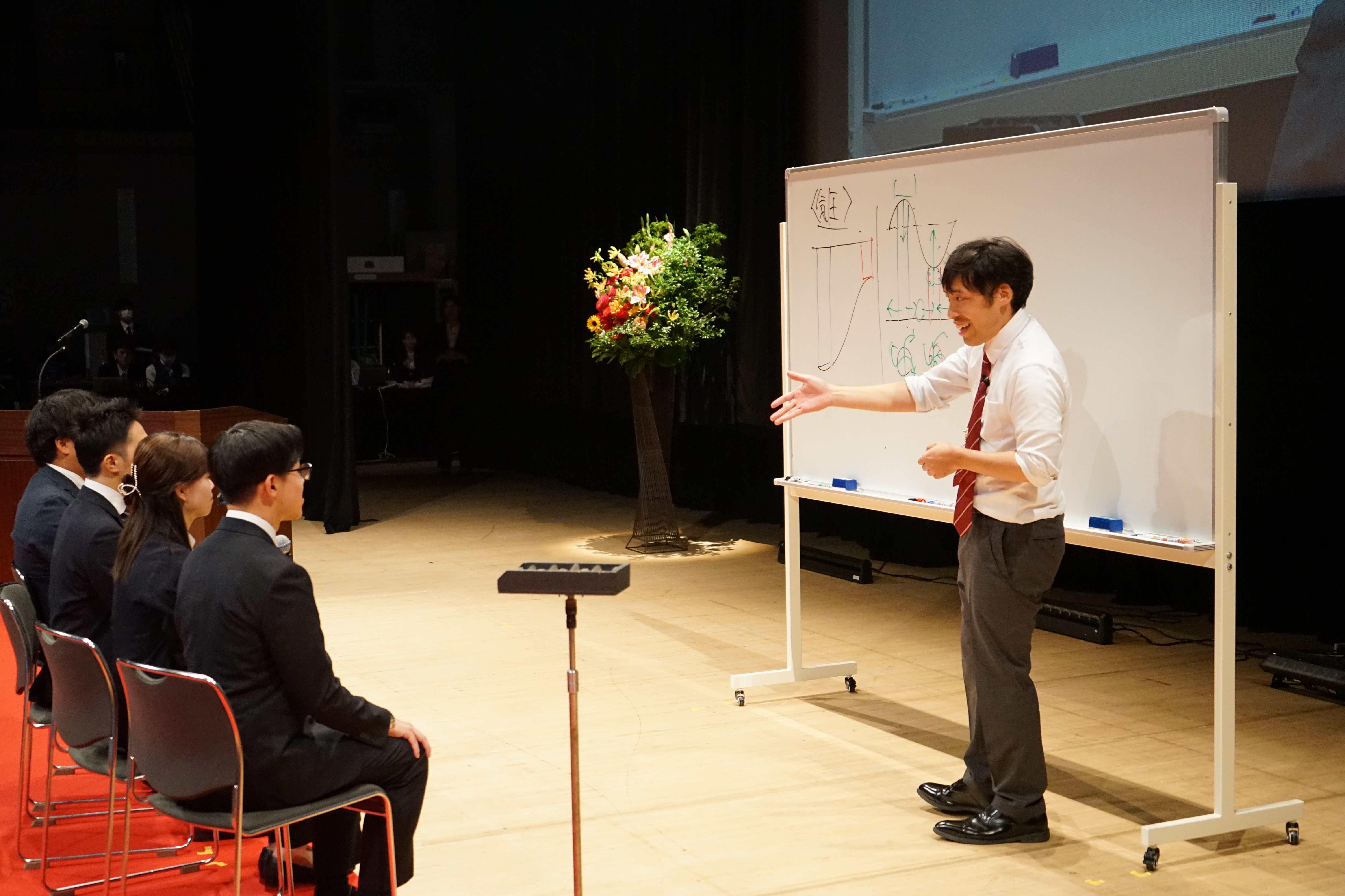 生徒役の社員を指名しながら授業を進める田村先生