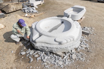 写真3 亀形石槽の製作(作業を行っているのは左野 勝司さん)