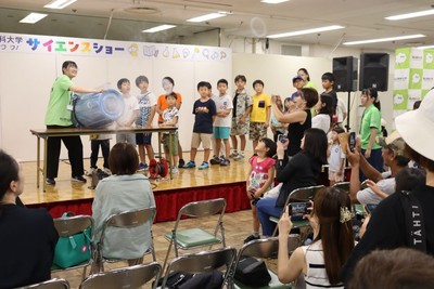 ステージから空気砲を順番に発射する子どもたち