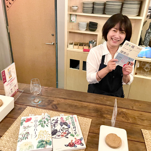 店主の辻先生。本日使用のハーブには沖縄ハーブ辞典に付箋が