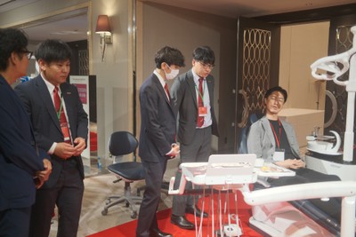 図5：営業社員から最新鋭の歯科用ユニットチェアK5（ケーファイブ)の説明を受ける参加者