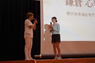 司会のおばたのお兄さんが保護者役を務めたロールプレイ競技。保護者への伝え方まで含めて保育者としての判断を表現した。写真右は大賞の鎌倉 心琴さん。