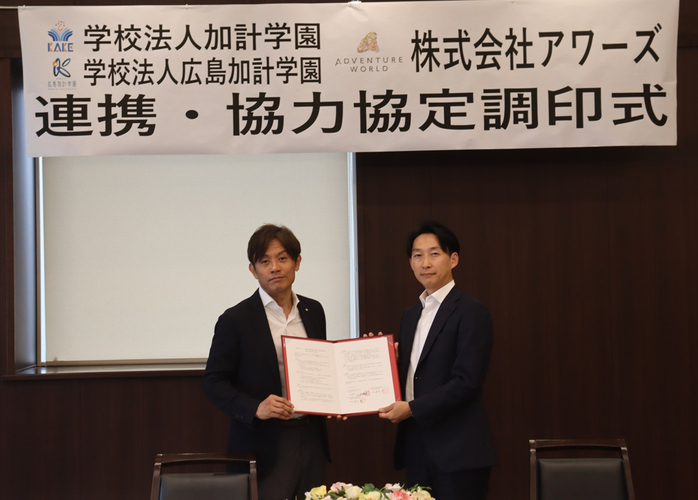 協定書を二人で持つ（左から）加計理事長、山本社長