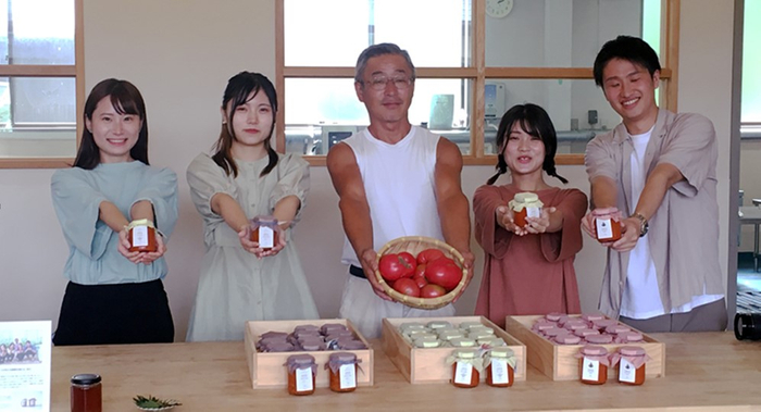 オリジナルトマトソースを手にする学生と曽爾村農家の寺前 健史さん