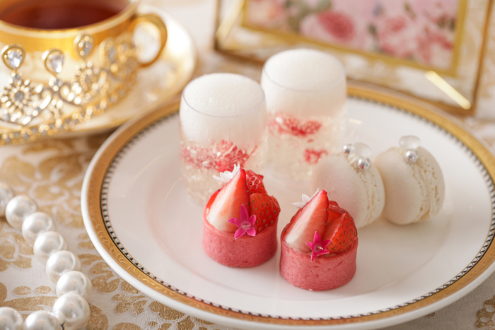 ▲スタンド中段スイーツ イメージ “祝杯~シャンパンジュレ~”は、フレッシュラズベリーと味わうシャンパンジュレ。 “ダイヤモンドリング~ルビーショコラのマカロン~”は、バタークリームと合わせてラズベリーのコンフィをサンドし酸味をプラス。 “ブーケ~いちごのタルト”は、華やかな一品。カスタードクリーム入りのいちごのタルト。