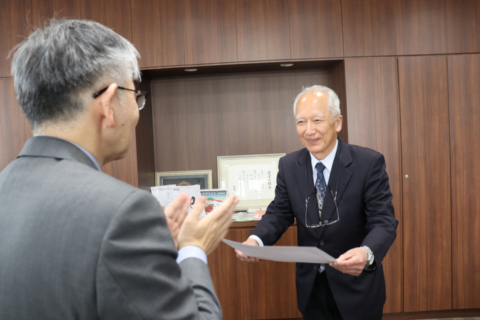 平野学長（左）から称号授与証を受け取る石垣元館長（右）
