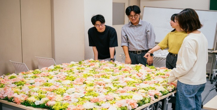 学生がフラワーフォトスポットの装飾物を制作する様子