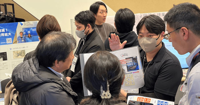 資料を囲み、熱心に導入相談を行う出展者と来場者の姿