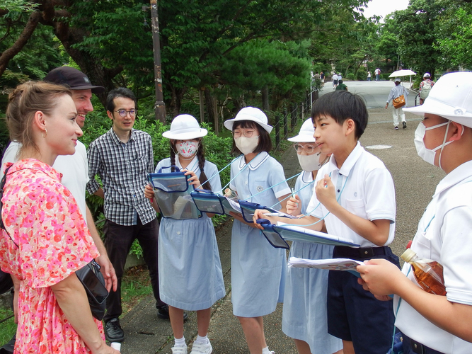 京都に訪れた外国人観光客へインタビューする児童たち