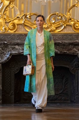 伊砂正幸氏の染色作品によるグリーンの羽織。ゴールドのボックス型バッグを手に