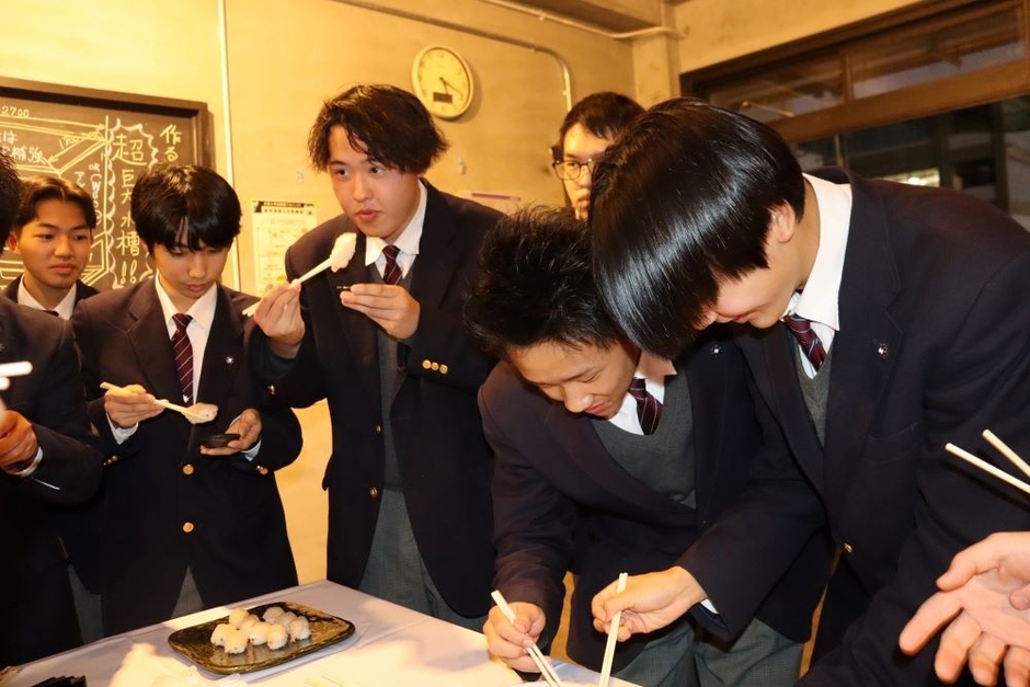自分たちで育てたタマカイを試食する生徒たち