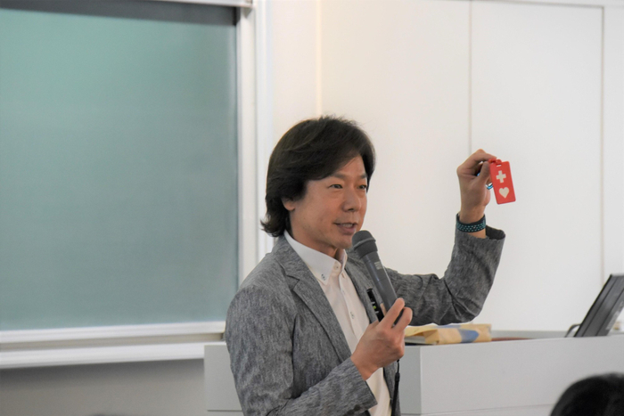 「ヘルプマーク」を示す佐藤特任教授