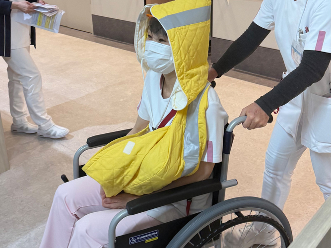 産科病棟で新生児避難具を使用し避難するシミュレーションを行う医療スタッフ(医誠会国際総合病院)