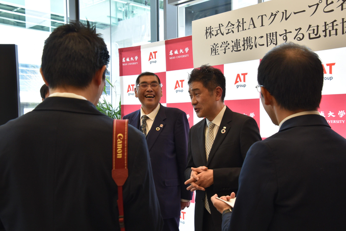 記者の囲み取材に応じる小原学長と山口社長