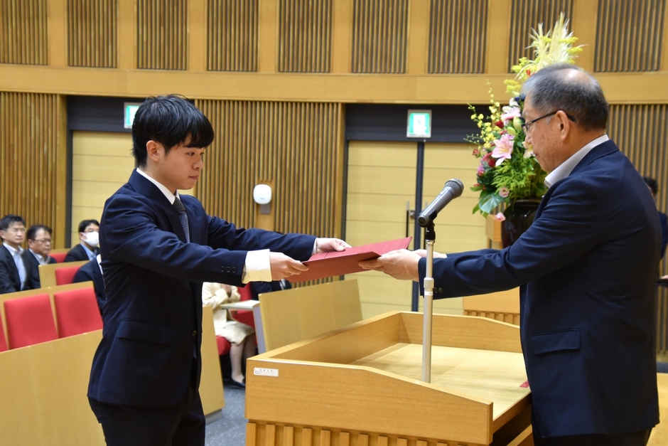 野口学長から学業優秀奨学生の決定通知を受け取る井口さん