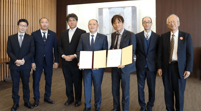 署名した覚書を手に記念写真に納まるバダムハタン所長（右から4人目）と加計理事長（右から3人目）