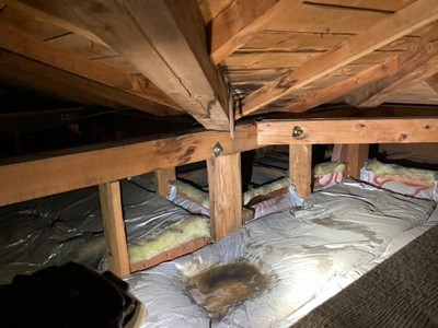 【画像3】銅板谷樋の穴開きにより屋根裏へ雨水浸入し、断熱材へ雨水が滞留しているようす(1)