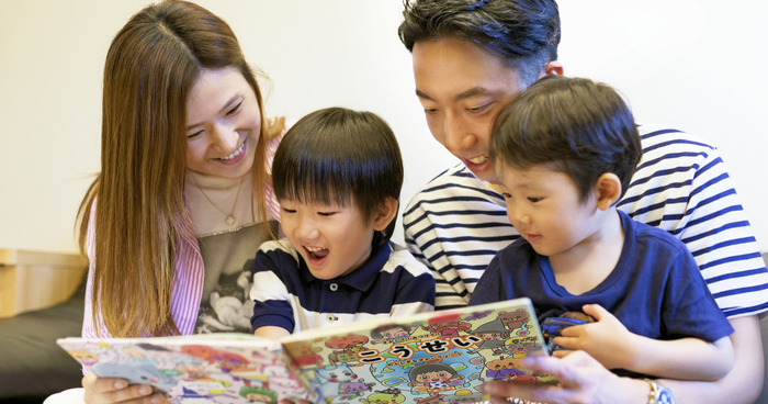 家族4人でマイステラの絵本を読む様子