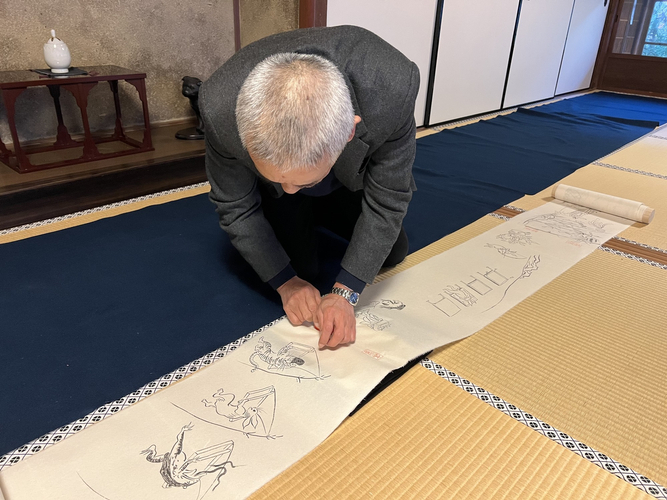 高山寺にて巻物の紙継に、今回復元制作した朱文長方印で捺印している様子