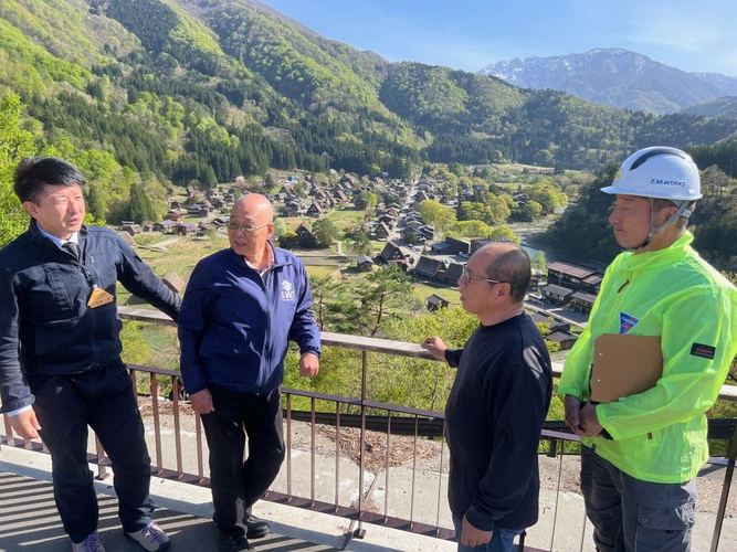 合掌造り集落の展望台で髙島課長（左端）から集落内でのクマの出現状況を聞く（その右から）辻特担教授、轟社長、渡邊さん