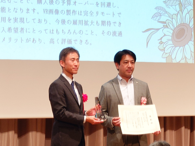 経済産業省 住宅産業室長 潮崎雄治様に表彰される、価値住宅株式会社代表取締役 高橋正典