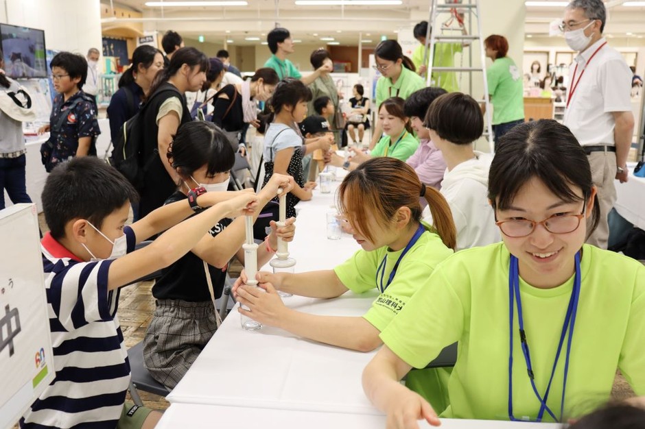 家族連れでにぎわう会場。写真は「空気を使って大実験!」のブース