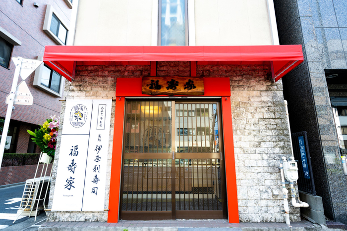 神社の鳥居をイメージした赤が基調の店舗外観