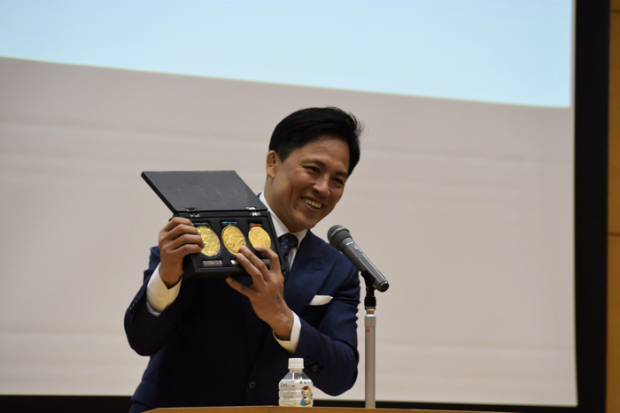 ３連覇の金メダルを披露する野村特任教授